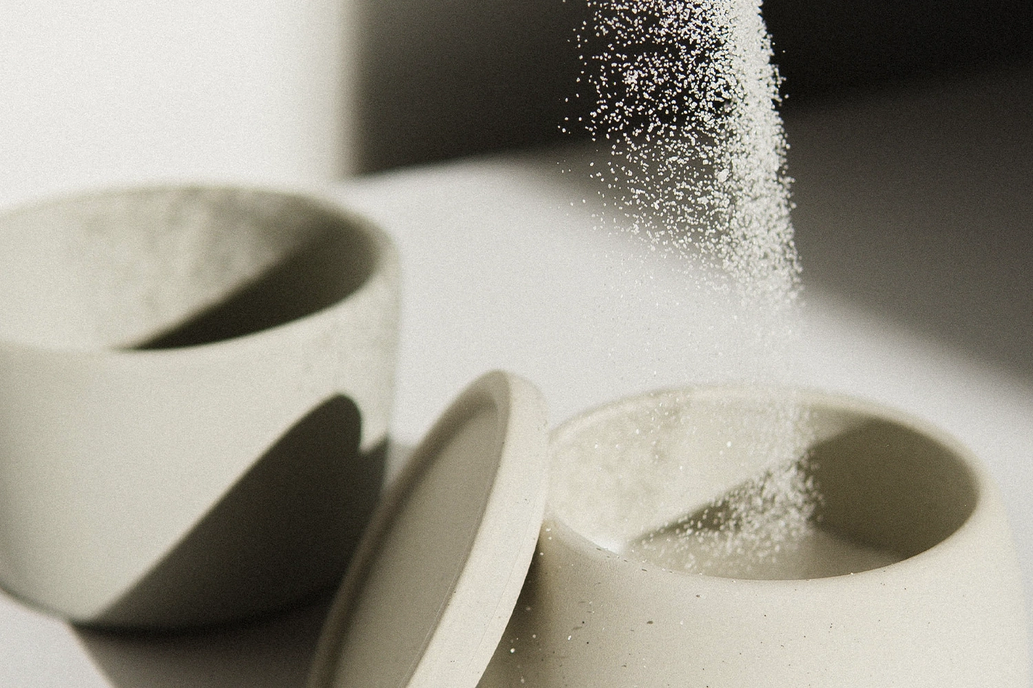 white sugar being poured into white ceramic container